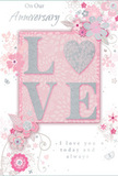 An anniversary card is displayed with a design that feels as gentle and intimate as a quiet evening at home in Feltham. The eye is drawn first to the bold word LOVE, set in large, slightly raised letters across the centre of the card. Each letter is coated in a fine, frosted glitter that shimmers with silvery light, giving the impression of softly glowing metal or moonlight on petals. The texture looks delicately grainy yet smooth to the touch, making the word both visually striking and invitingly tactile. Around this focal point, an array of illustrated flowers, buds, and curling vines drifts across a background washed in soft blush pink. The blossoms appear in pastel tones of pink, white, and pale grey, their shapes stylised yet recognisable as romantic garden flowers you might find in a thoughtfully arranged anniversary bouquet. Lines are drawn with the precision of a florist's sketch-fine, flowing, and slightly whimsical-suggesting movement, like stems gently swaying in a light breeze off Feltham Green. Occasional highlights in silver ink or foil accent the petal edges and leaf tips, adding tiny sparks of brightness that echo the card's celebratory purpose. Graceful cursive wording, possibly reading On Our Anniversary and I love you today and always, is placed in balanced harmony with the florals, much as a bouquet is balanced for shape and form. The entire composition is softly lit, allowing the pastel colours to appear calm and soothing while the glittered letters subtly catch the light. The mood is tender and reflective, capturing the feeling of a treasured anniversary marked with love, thoughtfulness, and quiet joy.